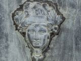a close up of a face on a stone wall