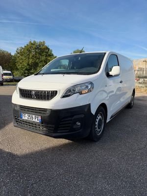 la camionnette blanche est garée dans un parking près d'un bâtiment