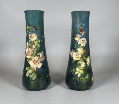 une paire de vases décorés de fleurs, posés sur une table