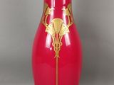 un vase rouge orné d'un motif doré