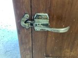 a close up of a door handle on a wooden cabinet