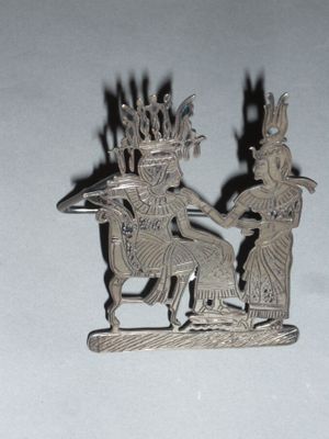 a silver statue of a man and a woman on a horse