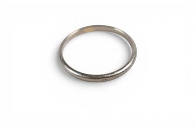 bague en argent posée sur une surface blanche, avec un petit trou au milieu