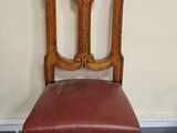 une vieille chaise en bois avec une assise en cuir marron, dans une pièce