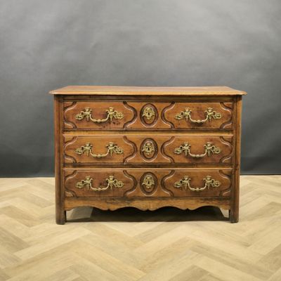 an antique chest of drawers with ornate carvings and brass handles