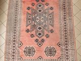un tapis orange et noir posé sur un sol carrelé blanc