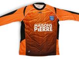 un maillot de foot orange et noir sur lequel est inscrit « Madison's Pierre »