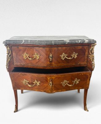 a small chest of drawers with marble top on it