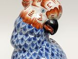 a figurine of a blue and white parrot on a white background