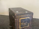 a small box sitting on a table in front of a mirror