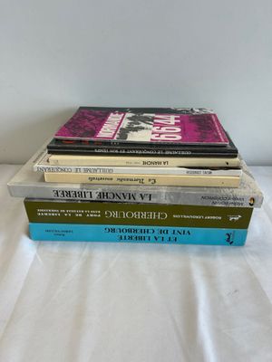 three books stacked on top of each other on a bed