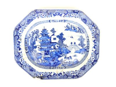 une assiette bleue et blanche sur laquelle est représenté un château