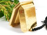 a small gold box with a black cord around it