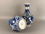 two blue and white vases sitting next to each other