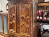 a large wooden armoire in the middle of a room
