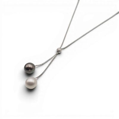 un gros plan sur un collier auquel sont suspendues deux perles
