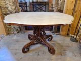 une table au plateau en marbre au milieu d'une pièce