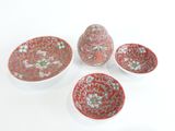 trois bols rouges et blancs et un bol orné d'un motif floral