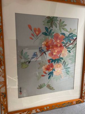 une photo d'une photo représentant un oiseau et des fleurs, dans un cadre