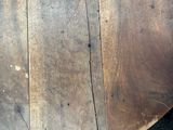 a close up of a wooden table on a black floor