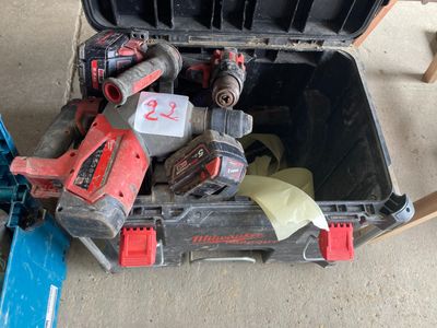 une boîte à outils contenant des outils, posée sur le sol