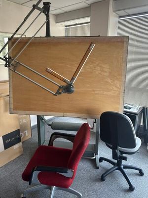 a desk with a chair and a large clock on it