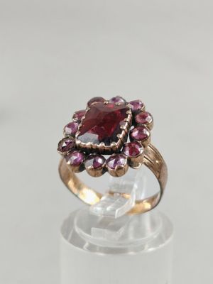 a close up of a ring with a red stone in it