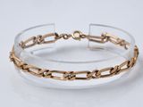 un gros plan d'un bracelet transparent et doré posé sur une surface blanche