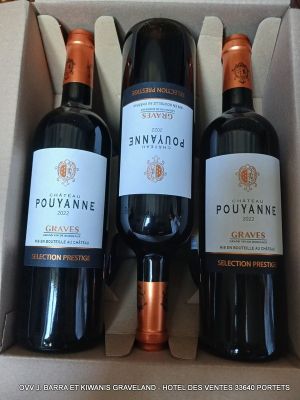 trois bouteilles de vin dans un coffret sur une table