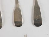 four spoons and a fork on a white surface