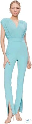 pregnant woman in a blue jumpsuit posing for a picture