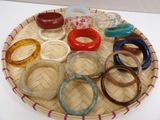 many different colored bracelets on a tray on a table