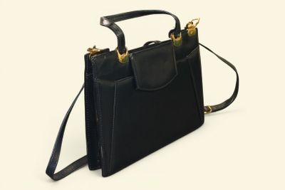 black leather handbag on a white background with a black strap