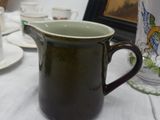 a white table cloth with a green cup and saucer on it