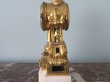 a gold statue sitting on a marble table