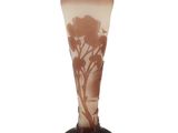 un vase en verre orné d'un arbre, posé sur un socle