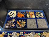 a blue box filled with lots of jewelry on a table
