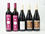 quatre bouteilles de vin sont alignées sur une surface blanche