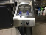 une cuisine équipée d'une cuisinière, d'un évier et d'un four