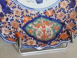 a plate with a blue vase on it on a stand