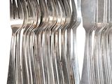 a lot of forks and spoons that are stacked together