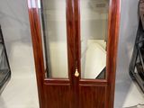 un meuble en bois avec une porte en verre dans une pièce