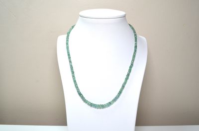 necklace made of green glass beads on a white mannequin