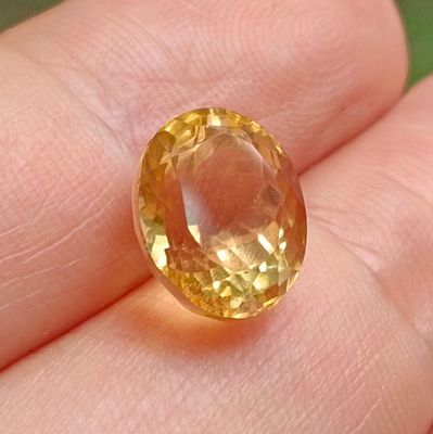 une image montrant un gros plan de la main d'une personne tenant un saphir jaune