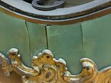 a green and gold clock on a table with a pair of scissors