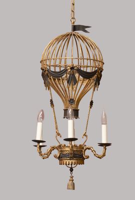 a gold colored light hanging from a chandelier with candles