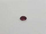 a red garnet stone on a white surface