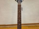 an acoustic guitar sitting on top of a wooden floor next to a wall