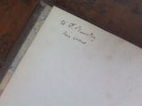 an old book with writing on it sitting on a table