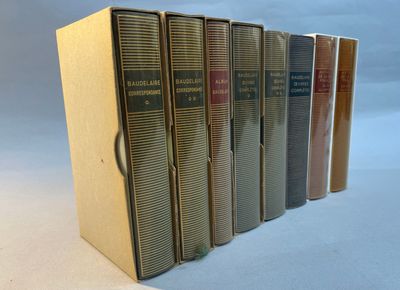 six books are lined up in a row on a white surface